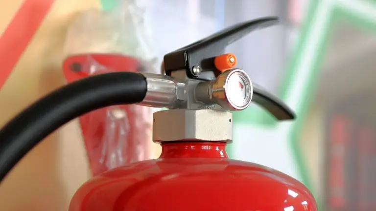 Close-up of a fire extinguisher pressure gauge and valve used to check whether the extinguisher is still charged