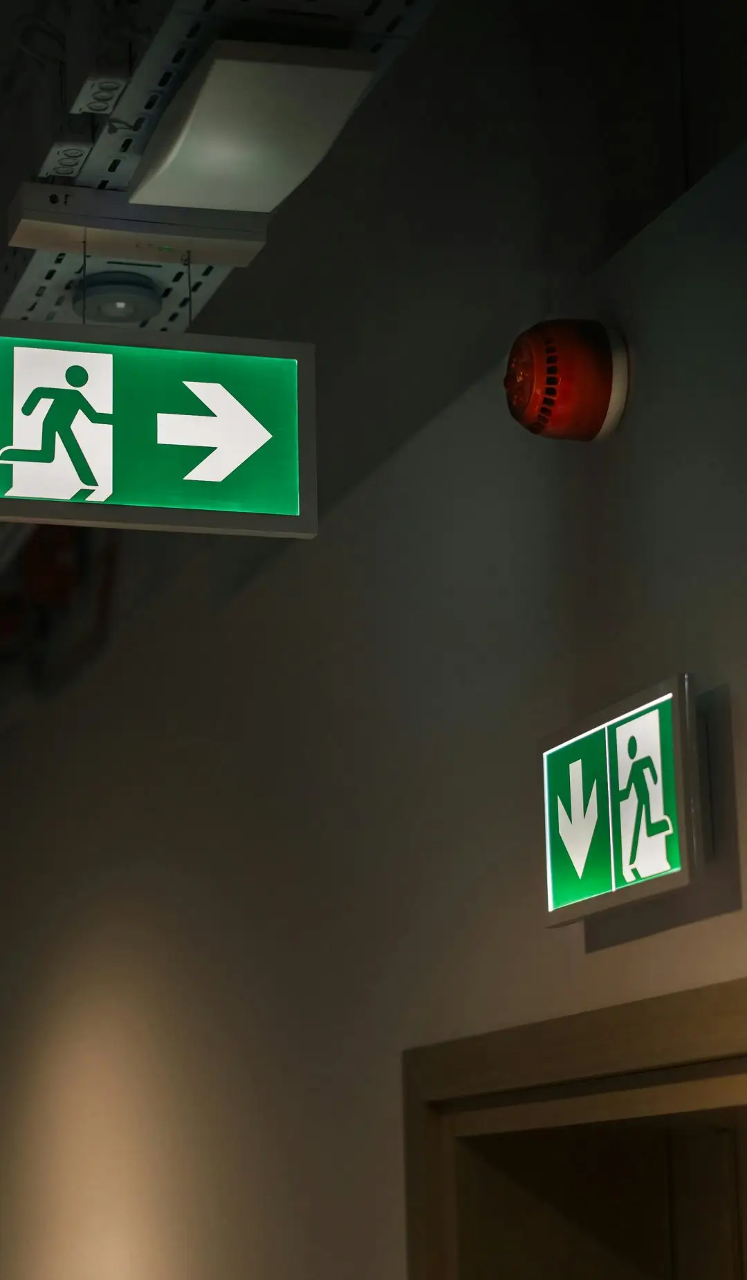 Illuminated exit signs along a corridor escape route in a Sydney commercial building