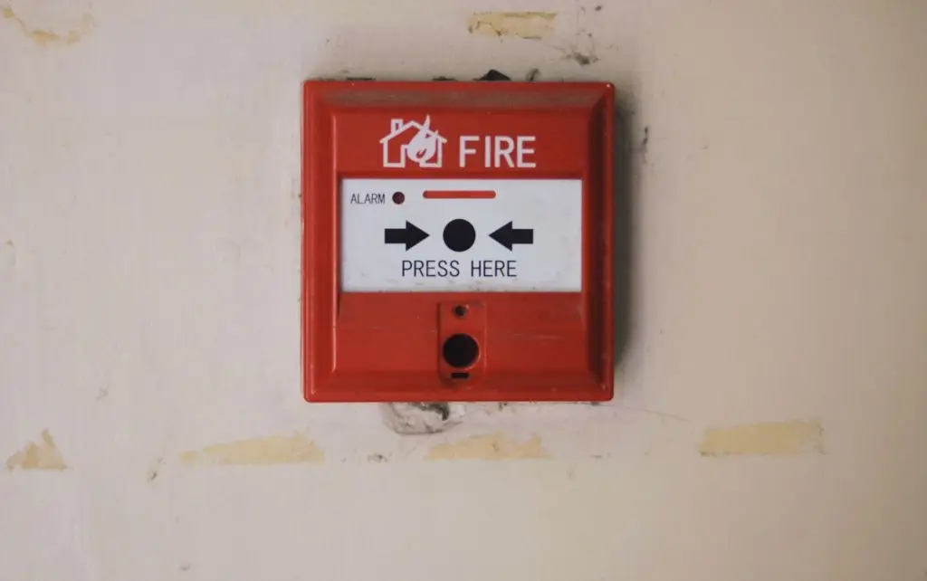 Red fire alarm manual call point mounted on a wall
