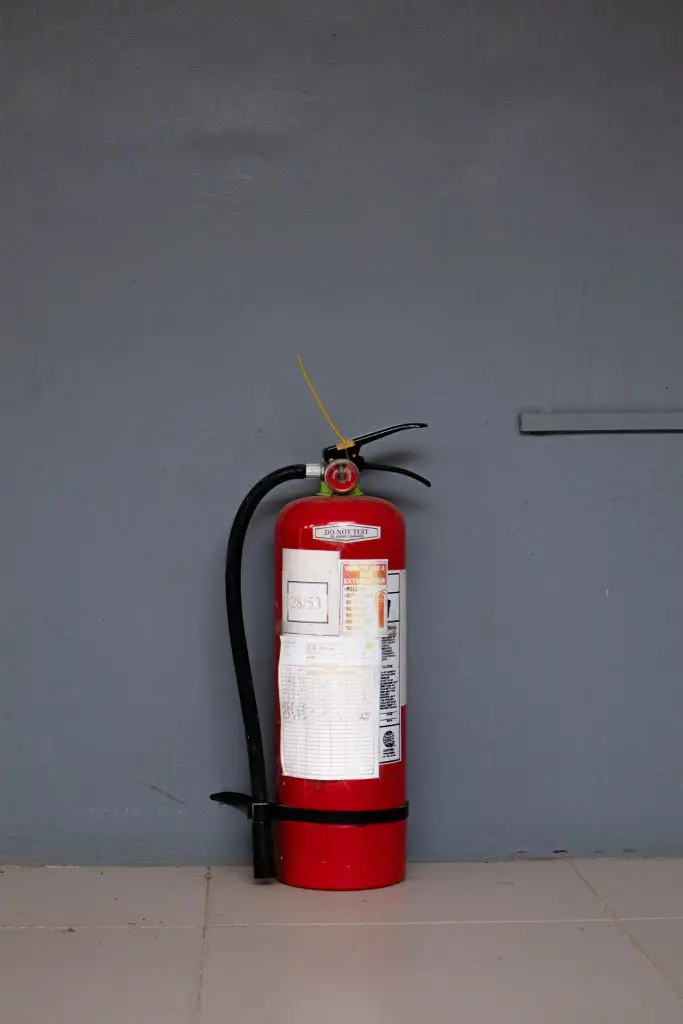 Portable fire extinguisher with English usage instructions and an inspection record tag
