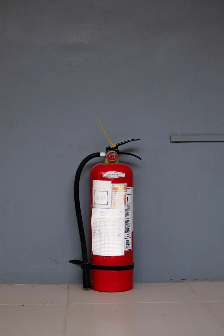 Portable fire extinguisher with English usage instructions and an inspection record tag